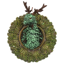 Detail of deer head wall decor with red eyes and ornate leaf pattern on round plaque