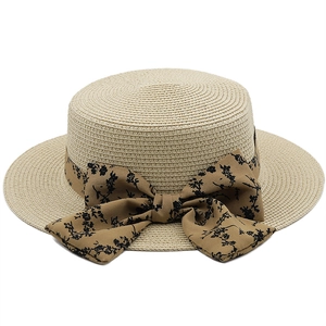 Detail of woven boater hat with a floral pattern ribbon and large bow decoration