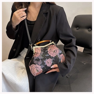Detailed view of black embroidery handbag with 3D pink flowers and wooden handle