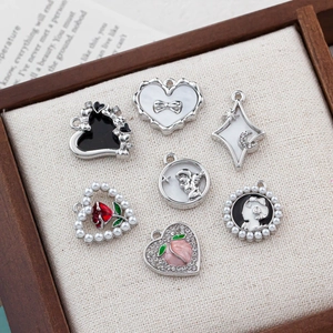 DIY jewelry charms set with pearls and rhinestones on beige linen display board