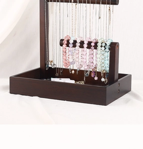 Detail view of double-tier wooden jewelry stand showing necklaces and bracelets
