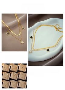 Detail view of double-layer gold necklaces with heart, star and pearl charms