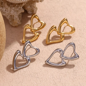 Detail of interlocking heart stud earrings in polished gold and silver stainless steel