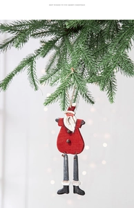 Close-up of wooden Christmas snowman pendant with a bell hanging on a pine tree branch