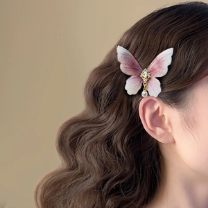 Detail of pink gradient butterfly hair clip with zircon center and pearl drop pendant