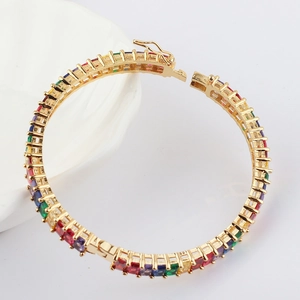 Detail of bohemian rainbow tennis bracelet with multi-color zircon stones in gold finish
