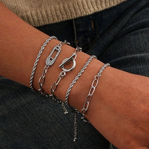 Détail d'un ensemble de cinq bracelets en métal argenté avec trombone et fermoir en T