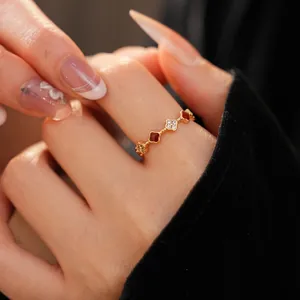 Macro shot of 18k gold plated clover ring with red enamel and pavé zircon stones