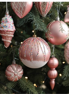 Detail of pink and rose gold Christmas ornaments with glitter on a festive green tree