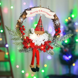 Detail of Christmas wreath with Santa, LED lights, and Merry Christmas sign on rattan