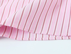 Gros plan détaillé de rayures verticales roses et rouge foncé sur tissu en coton respirant
