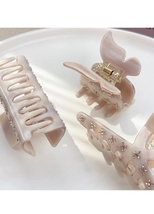 Detailed view of pink acetate hair claws with small rhinestones and butterfly design