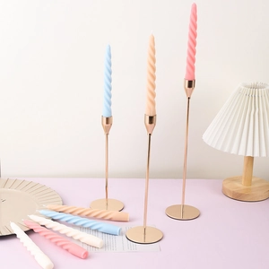 Close-up of colorful spiral taper candles on elegant gold metal candle holders