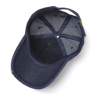 Close-up of internal seams and metal buckle on dark blue denim baseball cap