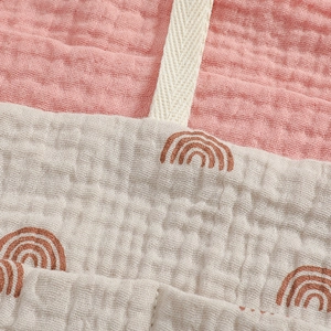 Detailed macro view of breathable pink cotton muslin fabric with rainbow print and woven strap