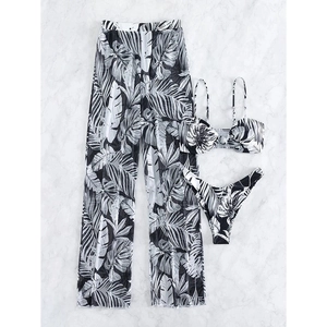 Three-piece bikini set with tropical palm leaf print and mesh trousers on marble