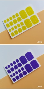 Close-up of J005 yellow and J006 purple glitter toe nail stickers with 22 pieces per sheet