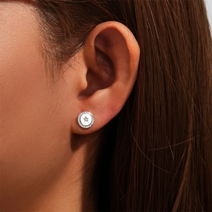 Macro shot of a minimalist S925 sterling silver round stud earring with a central star pattern