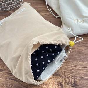 Detail of drawstring storage bags featuring embroidery on premium fabric for travel organization
