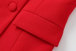 Close-up of red woven suit vest showing pocket flap and matching fabric-covered button