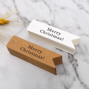 Pila di etichette regalo di Natale in carta bianca e kraft su fondo marmo