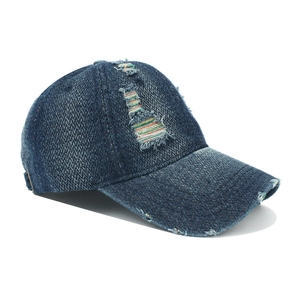 Detail of distressed navy denim baseball cap with colorful stitching and ripped effects