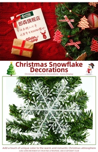 Close-up of white snowflake ornament with iridescent glitter on green pine branches