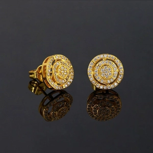Macro shot of hip-hop round gold earrings with micro-paved zircons on black mirror