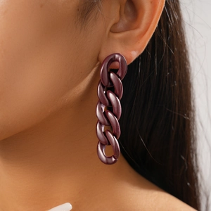 Close-up of deep purple acrylic chain link drop earrings worn by a model in profile