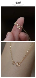 Detail of 14K gold plated S925 silver necklace with two flower pendants and white zircons