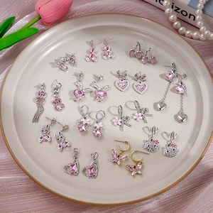 Ensemble de boucles d'oreilles lapin rose et cœur avec strass sur un plateau décoratif