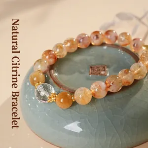 Elegant citrine crystal bead bracelet with gold accents on a ceramic base zen style