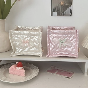 Detailed view of quilted storage baskets with heart patterns and lace bow accents