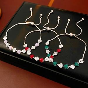 Detailed macro of vintage zircon heart bracelets in purple, red, and green enamel