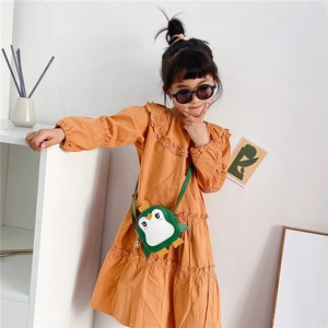 Detailed view of children's penguin crossbody bag paired with a brown frill dress