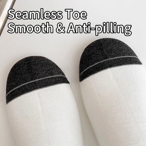 Gros plan de chaussettes en coton sans couture avec tissu anti-boulochage noir et blanc