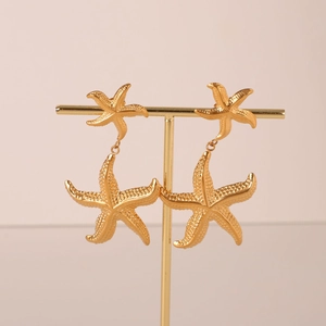 Elegant 18k gold plated stainless steel starfish drop earrings on a golden display stand