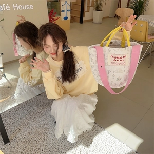 Détail d'un sac seau matelassé à fleurs avec motifs lapins et bandoulières
