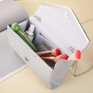 Detail view of silver clutch bag interior showing chain strap and storage capacity