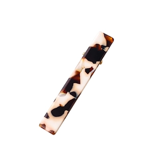 Minimalist tortoiseshell acetate hair clip with golden metal base for elegant hair styling