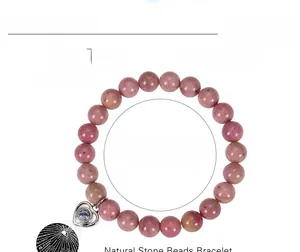Macro detail of 8mm pink rhodochrosite beaded bracelet with heart projection pendant