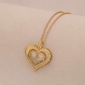 Macro shot of gold heart pendant with micro-paved zircons on minimalist metal chain