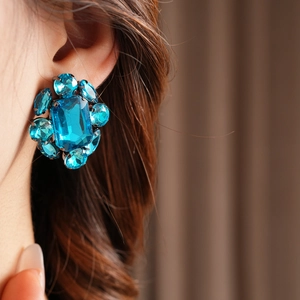 Détail du mannequin portant des boucles d'oreilles fleur en cristal bleu style vintage