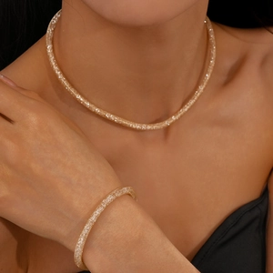Close-up of sparkling gold zircon necklace and bracelet set worn by a model