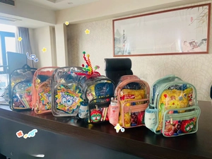 Multiple colorful transparent PVC backpacks showcasing storage capacity and zip pockets