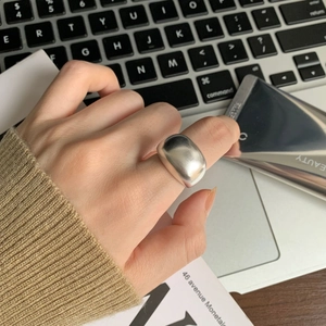 Polished silver wide-band ring shown on a laptop keyboard in a modern lifestyle setting