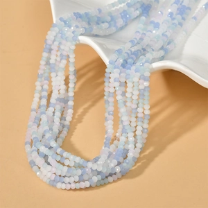Close-up of 3mm blue and white gradient faceted crystal beads on a white plate