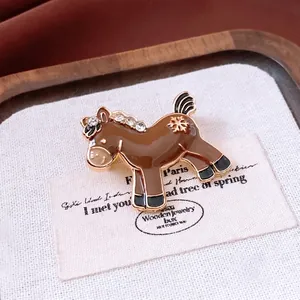 Vintage gold pony brooch with brown enamel, white rhinestones and snowflake detail