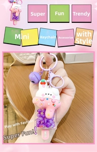 Detail of bunny cream ice cream keychain with purple beads and bell accessories