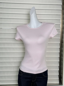 Close-up of pink slim fit crew neck T-shirt fabric and seam detail on a white mannequin